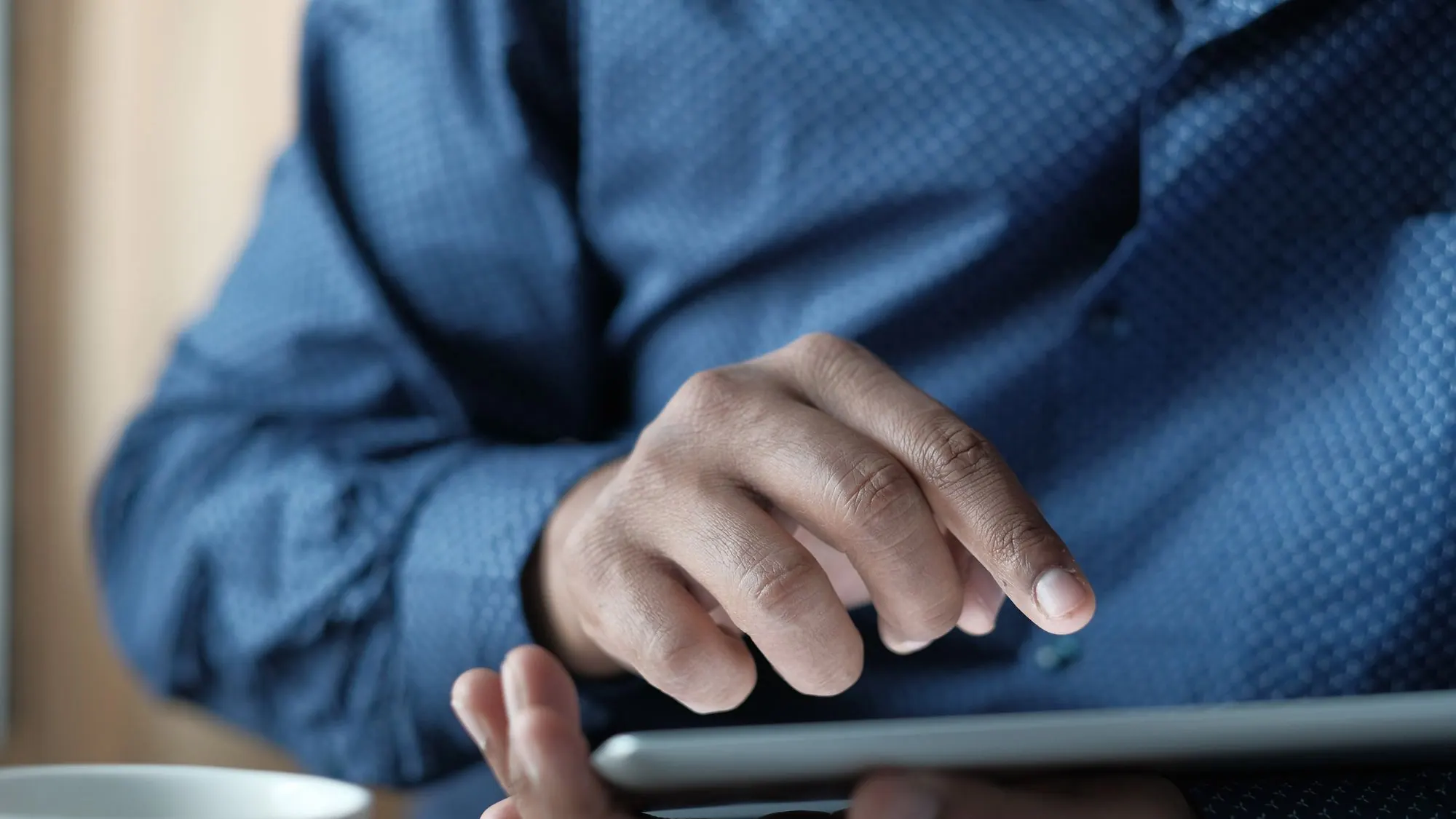 Manos consultando un contenido en una tableta