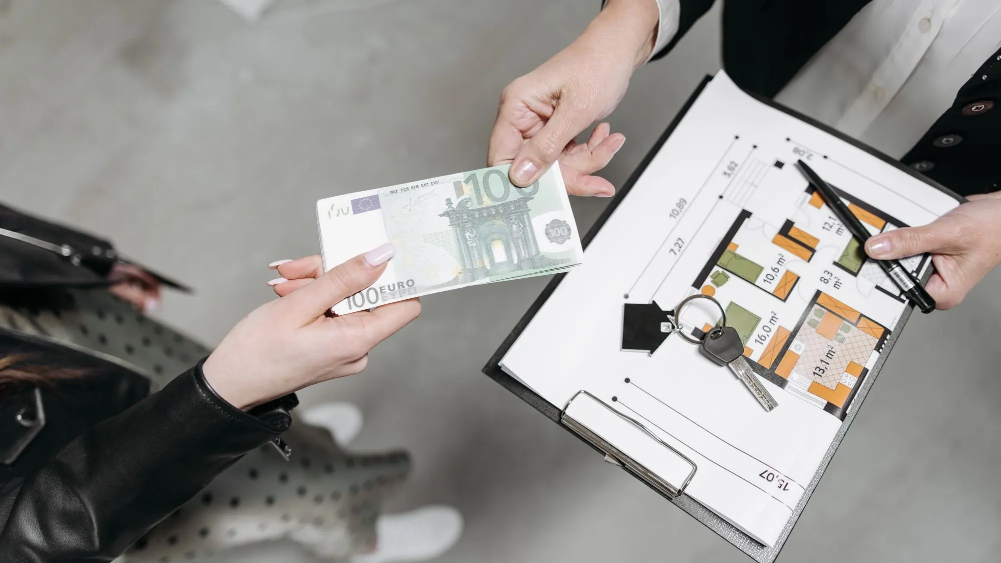 Llaves de una vivienda sobre un plano junto a un billete de euro