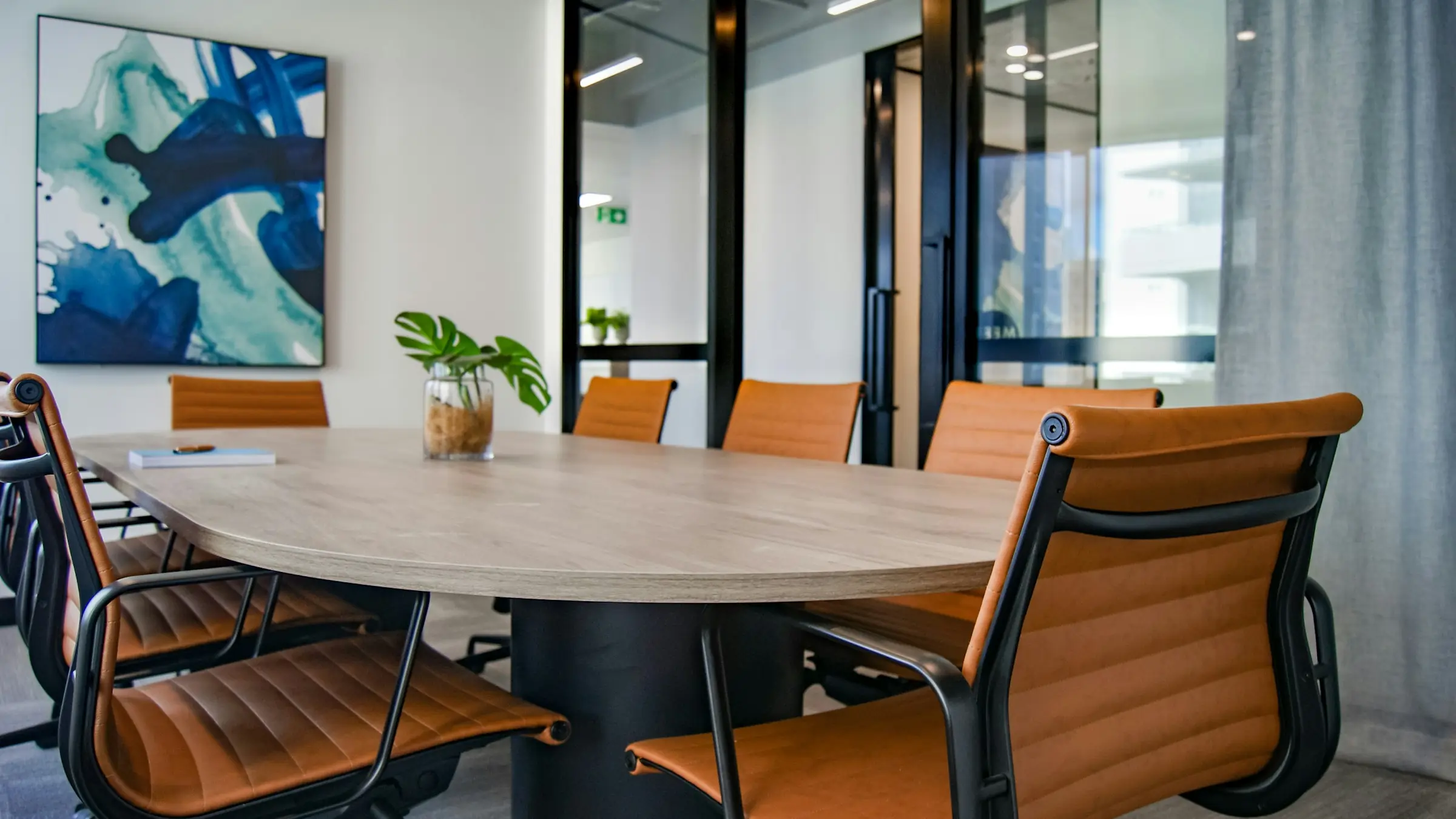 Mesa de reuniones de madera con sillas en un despacho